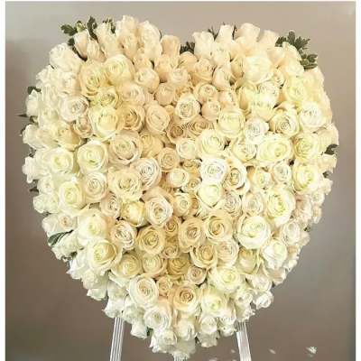 Heart-shaped bouquet of white and cream roses on a stand