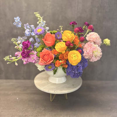 Colorful mixed bouquet in a white pedestal vase