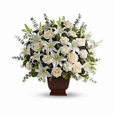 White lilies and roses arranged in a brown urn vase