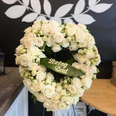 Heart-shaped white rose wreath with a "Loving Dad" plaque
