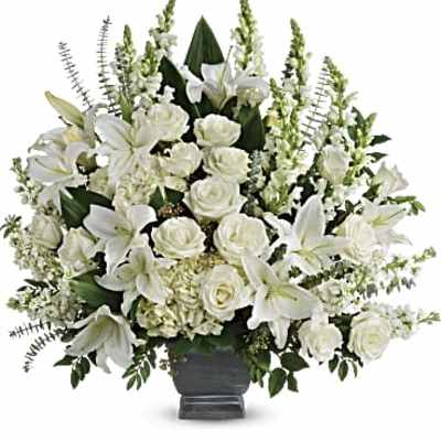 White lilies and roses arranged in a dark vase