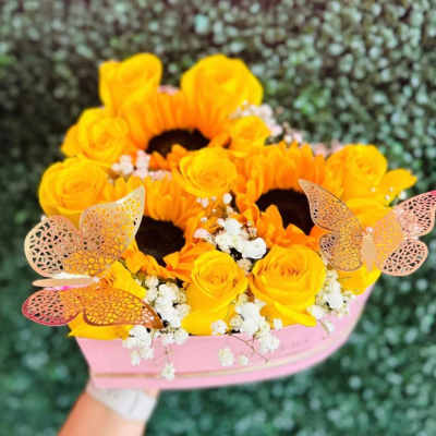 Yellow roses and sunflowers in a pink wrapped bouquet with butterfly accents
