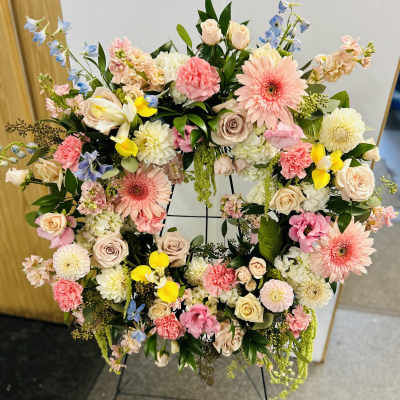 Large floral wreath with pink, cream, yellow, and blue flowers