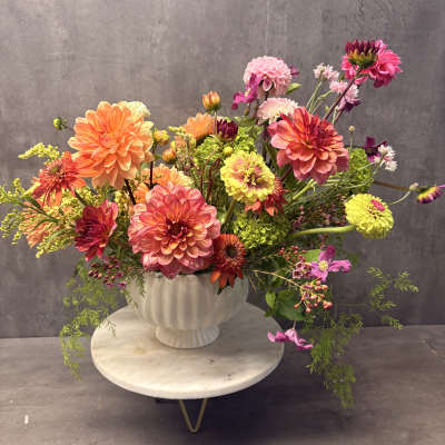 Colorful mixed bouquet of dahlias in a white vase