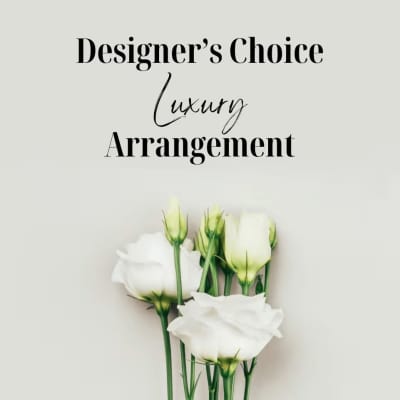 White rose buds with green stems under "Designer’s Choice Luxury Arrangement" text