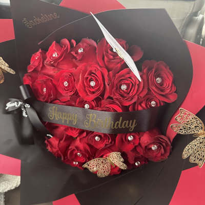Red rose bouquet with black and red wrapping and a Happy Birthday ribbon