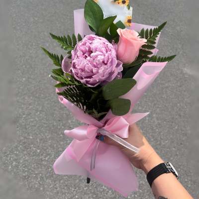 Pink peony and rose bouquet wrapped in pink paper