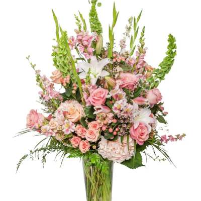 Tall pink and white floral arrangement in a glass vase