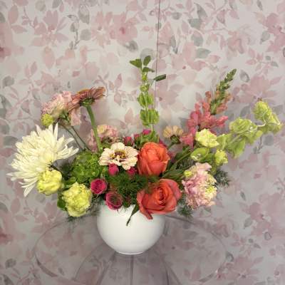 Mixed bouquet in a white vase with pink, orange, and white blooms