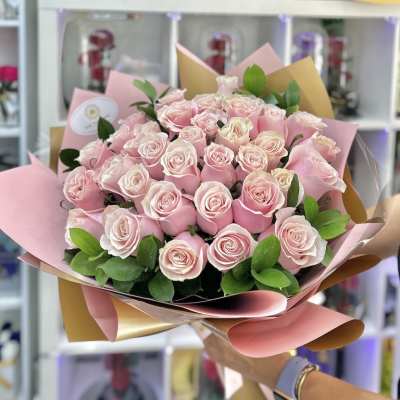 Large hand-tied bouquet of light pink roses wrapped in pink and tan paper
