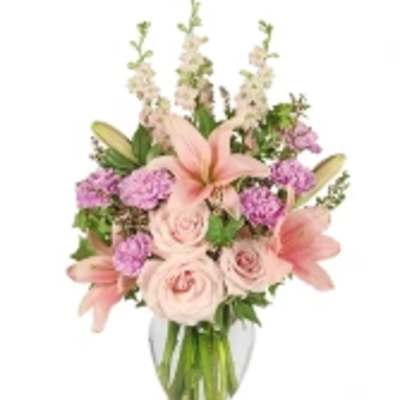 Pink lilies and roses in a clear glass vase