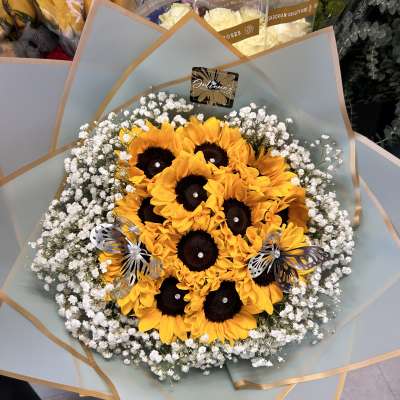 Bouquet of sunflowers with white baby's breath in pale blue wrap