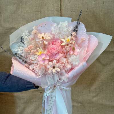 Pink rose bouquet with pastel filler flowers and white wrapping