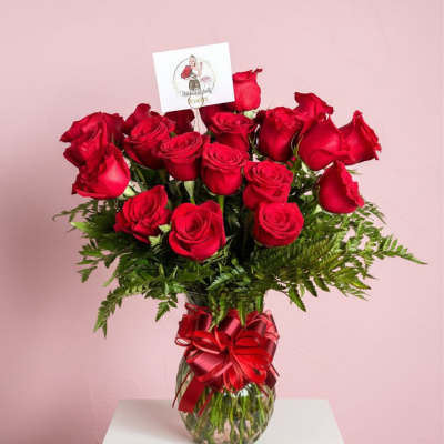 Red roses in a glass vase with a red ribbon bow