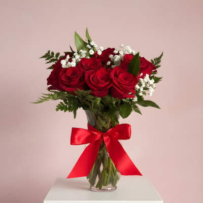 Red roses in a glass vase with a red ribbon
