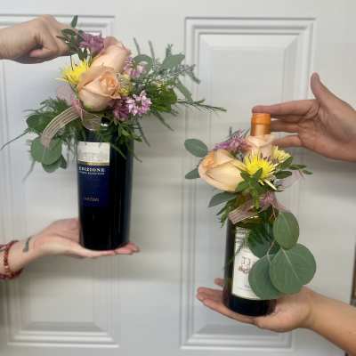 Wine bottles topped with small floral arrangements