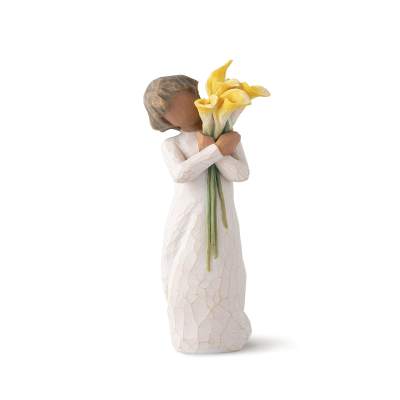 Figurine of a child holding yellow calla lilies
