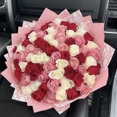 Large bouquet of pink, red, and white roses wrapped in pink paper