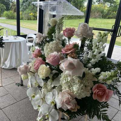 Tall wedding floral arrangement with pink and white roses and orchids