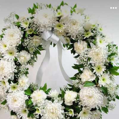 White floral wreath with a satin ribbon bow