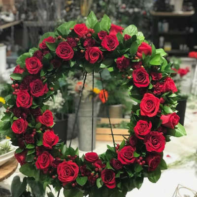 Circular wreath of red roses with green foliage