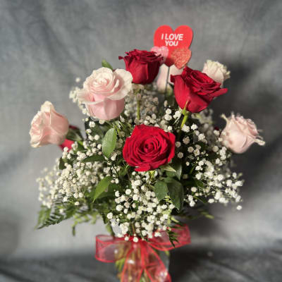 Bouquet of red and pale pink roses with a heart topper and red ribbon
