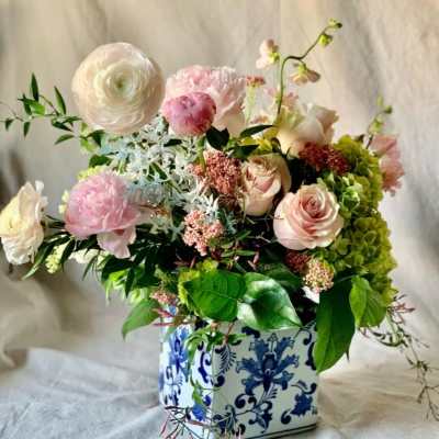 Pink and white floral arrangement in a blue-and-white ceramic vase