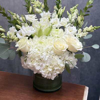 White floral arrangement in a dark green vase