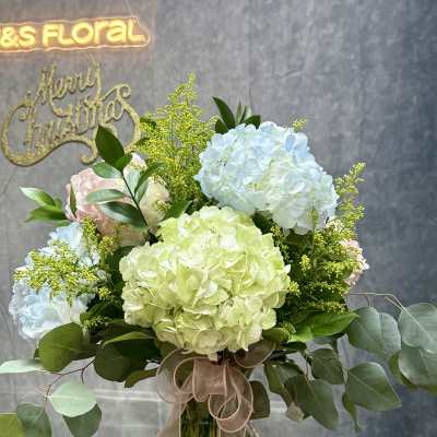 Hydrangea bouquet in a glass vase with a ribbon bow