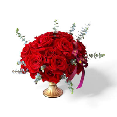 Red rose bouquet in a gold vase with eucalyptus accents
