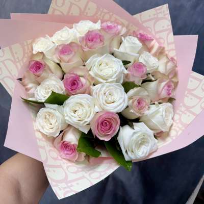 Bouquet of pink and white roses wrapped in pink paper