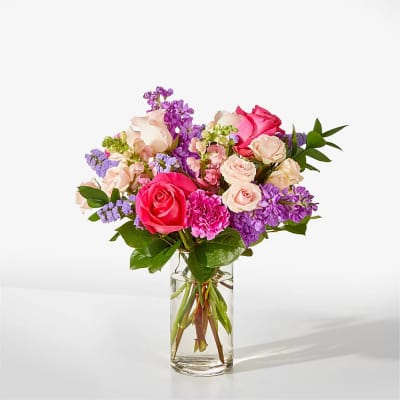 Bouquet of pink and purple roses in a clear glass vase