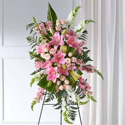 Tall pink lily and rose standing spray on a black easel