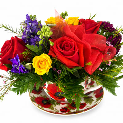 Bouquet of red, yellow, and purple roses in a floral teacup and saucer