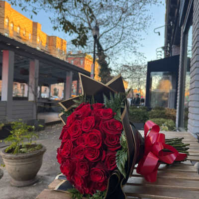 Bouquet of red roses wrapped in black paper with a red ribbon