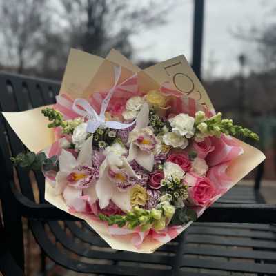 Pink and white mixed bouquet wrapped in paper with ribbon