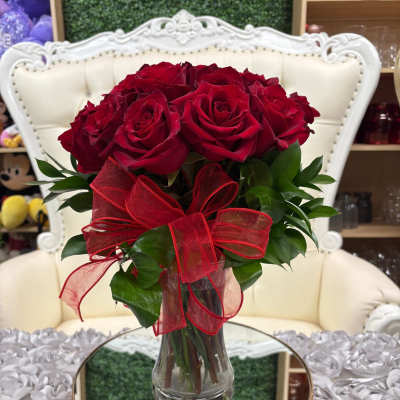 Bouquet of red roses in a clear glass vase with a red ribbon