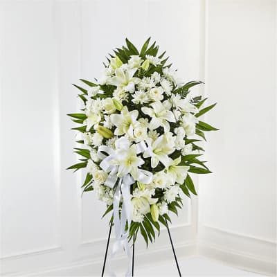 White floral standing spray on an easel with a ribbon