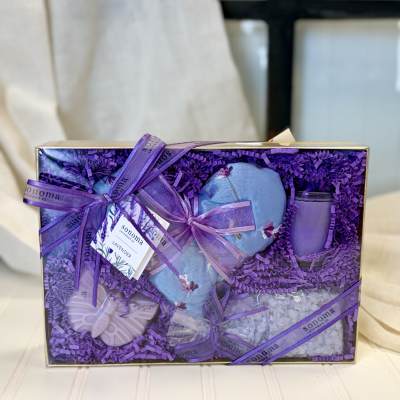 Lavender-themed gift box with a heart-shaped item, candle, and bath items