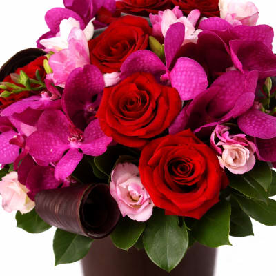 Bouquet of red roses and pink orchids in a vase
