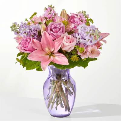 Pink and lavender bouquet in a purple glass vase