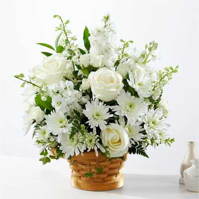 White roses and daisies arranged in a woven basket
