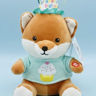 Plush fox wearing a birthday hat and cupcake shirt