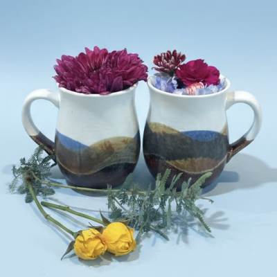 Pair of pottery mugs with wildflowers
