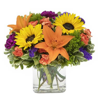 Bouquet of sunflowers, orange lilies, and purple flowers in a glass vase