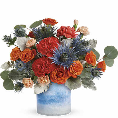 Orange and red flower arrangement in a blue ceramic vase