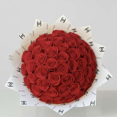 Round bouquet of red roses wrapped in white Chanel paper
