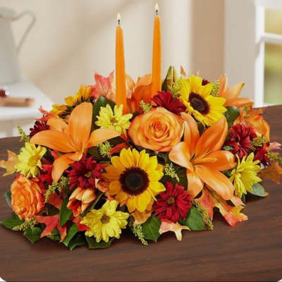Autumn floral centerpiece with orange candles and mixed blooms