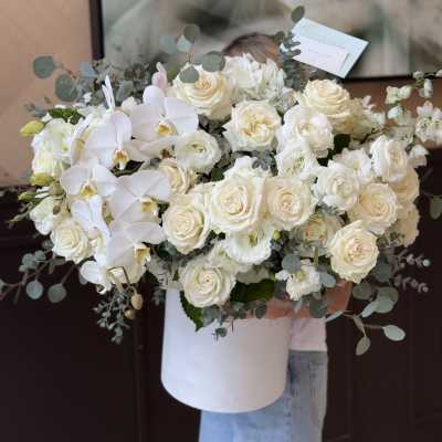 Large white bouquet of roses and orchids in a white box