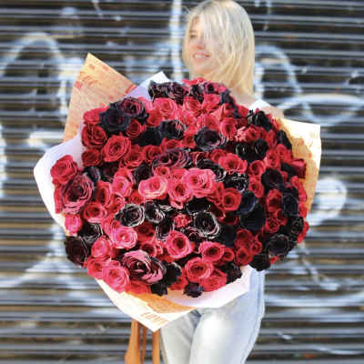 Large bouquet of pink and dark red roses wrapped in printed paper